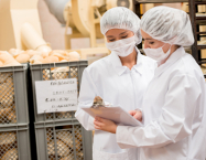 deux femmes en uniforme blanc dans une entreprise alimentaire